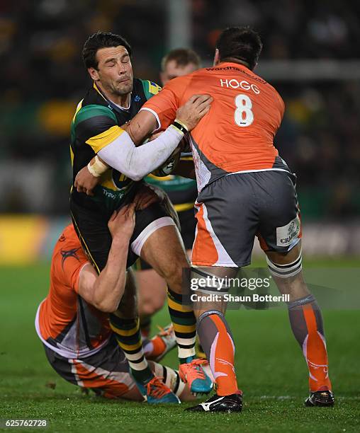 Ben Foden of Northampton Saints is tackled by Callum Chick and Ally Hogg of Newcastle Falcons during the Aviva Premiership match between Northampton...