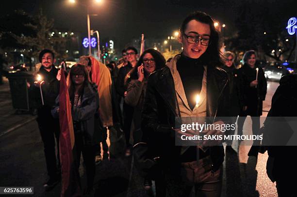 Demonstrators hold candles during a protest march for the International Transgender Day of Remembrance in Thessaloniki on November 25, 2016. / AFP /...