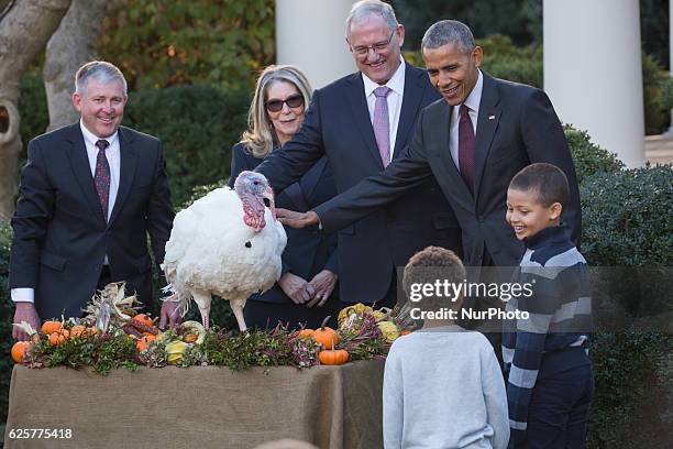 President Barack Obama pardons the National Thanksgiving Turkey, 'Tot,' with his nephews Aaron and Austin Robinson and National Turkey Federation...