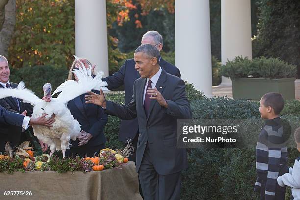 President Barack Obama stands with his nephews Austin and Aaron Robinson as he pardons the National Thanksgiving Turkey in the Rose Garden of the...