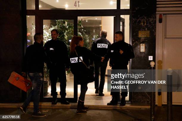 French police officers arrive at the building where British photographer David Hamilton was found dead at his home on November 25, 2016 in Paris....