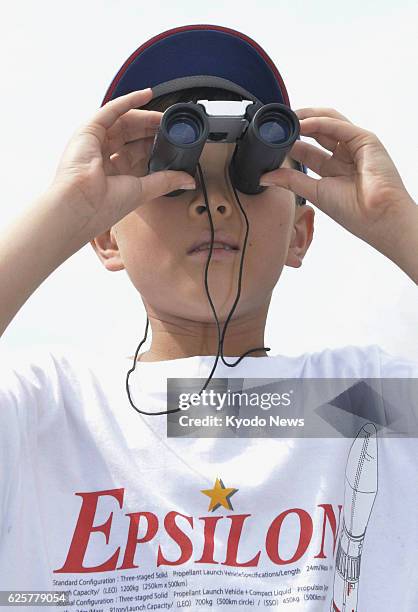 Japan - A boy uses binoculars to see Japan's new solid-fuel rocket Epsilon as it sits on the launch pad at the Uchinoura Space Center in Kimotsuki,...