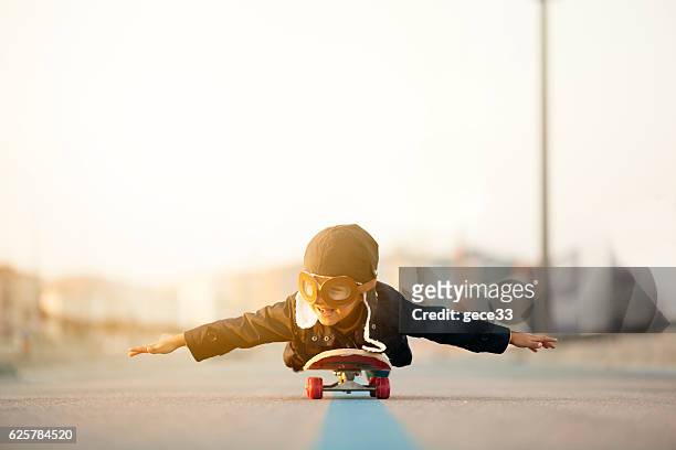 junge fliegen auf skateboard präsentiert - fliegerbrille stock-fotos und bilder