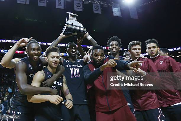 The Temple Owls celebrate with the trophy after defeating the West Virginia Mountaineers 81-77 during the championship game of the NIT Season Tip-Off...