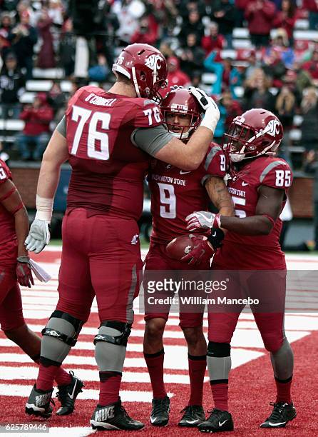 Cody O'Connell and John Thompson of the Washington State Cougars congratulate teammate Gabe Marks after his touchdown against the Washington Huskies...