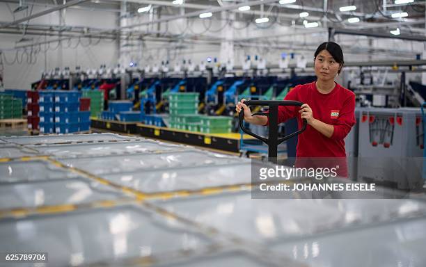 This picture taken on November 24 shows a worker working in the packaging section of the newly opened Lego factory in Jiaxing. Lego's first Asian...