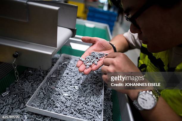 This picture taken on November 24 shows a worker checking the production in the moulding section of the newly opened Lego factory in Jiaxing. Lego's...