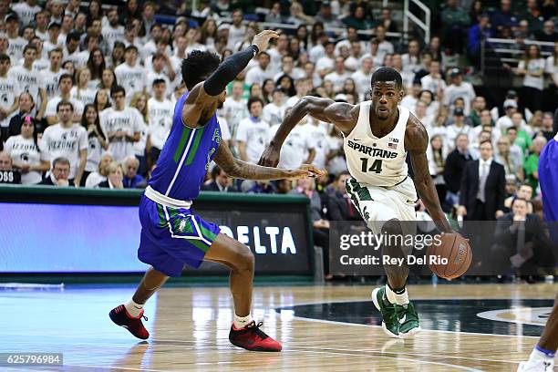 Eron Harris of the Michigan State Spartans handles the ball in the second half against Reggie Reid of the Florida Gulf Coast Eagles on November 20,...