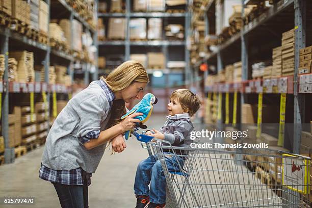 mother with her kid in a store - shopping humor stock pictures, royalty-free photos & images