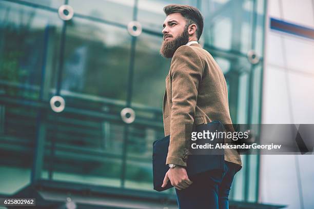 uomo d'affari hipster con borsa per laptop che cammina sulla city street - beard men street foto e immagini stock