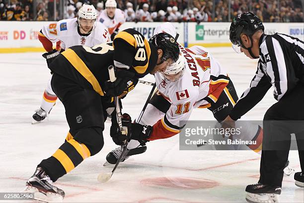 Dominic Moore of the Boston Bruins faces off against Mikael Backlund of the Calgary Flames at the TD Garden on November 25, 2016 in Boston,...