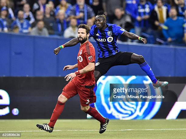 Dominic Oduro of the Montreal Impact jumps behind Drew Moor of the Toronto FC during leg one of the MLS Eastern Conference finals at Olympic Stadium...