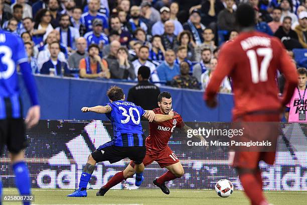 Hernan Bernardello of the Montreal Impact challenges Sebastian Giovinco of the Toronto FC during leg one of the MLS Eastern Conference finals at...