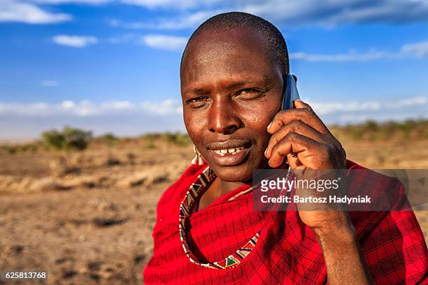 warrior from maasai tribe using mobile phone, kenya, africa - kenyansk kultur bildbanksfoton och bilder