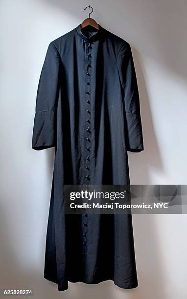 view of the priest robe hanging on a wall. - priest stock-fotos und bilder