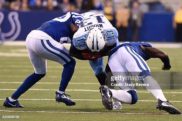 Kendall Wright of the Tennessee Titans is brought down by Darius Butler and Vontae Davis of the Indianapolis Colts during a game at Lucas Oil Stadium...