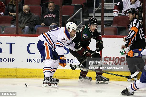 Arizona Coyotes defenseman Connor Murphy passes the puck defended by Edmonton Oilers left wing Milan Lucic during the NHL hockey game between the...