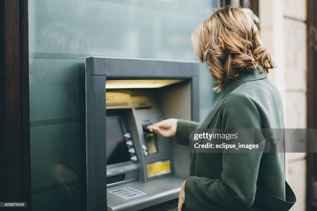 Young woman using ATM