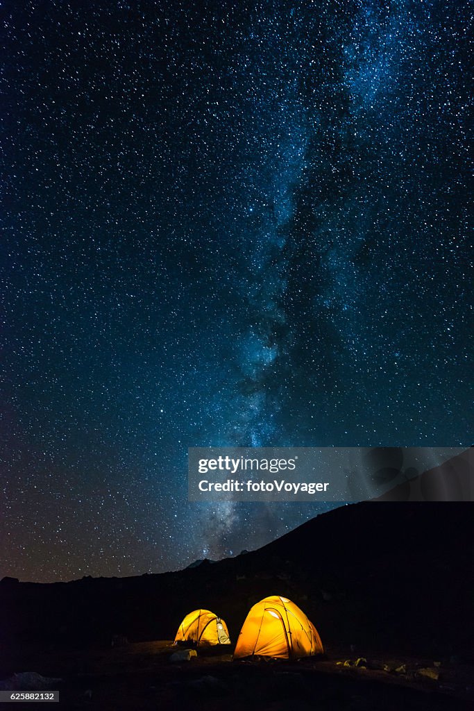 Milky way stars shining over illuminated mountain tents Himalayas Nepal