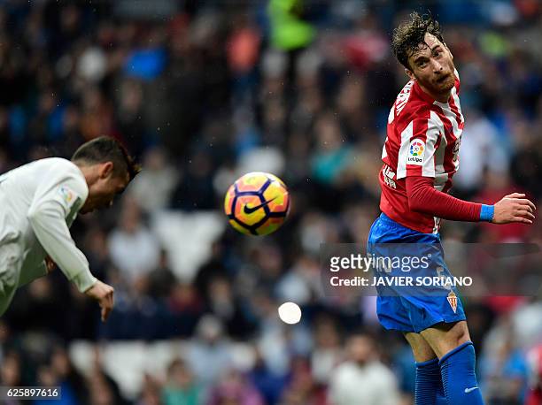 Real Madrid's Portuguese forward Cristiano Ronaldo heads the ball to score his second goal beside Sporting Gijon's Venezuelan defender Fernando...