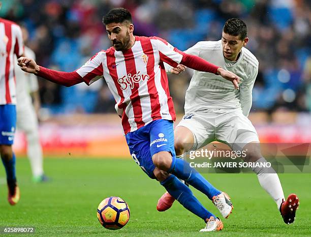 Sporting Gijon's midfielder Carlos Carmona vies with Real Madrid's Colombian midfielder James Rodriguez during the Spanish league football match Real...