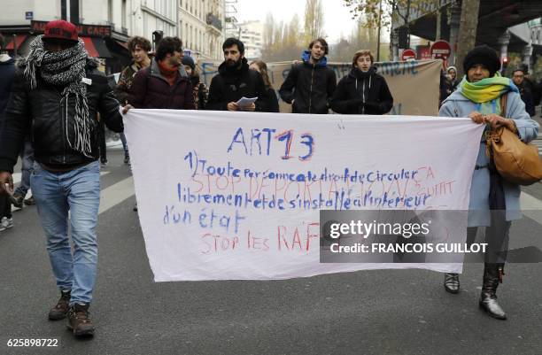 People hold a banner reading article 13 of the Universal Declaration of Human Rights "Everyone has the right to freedom of movement and residence...