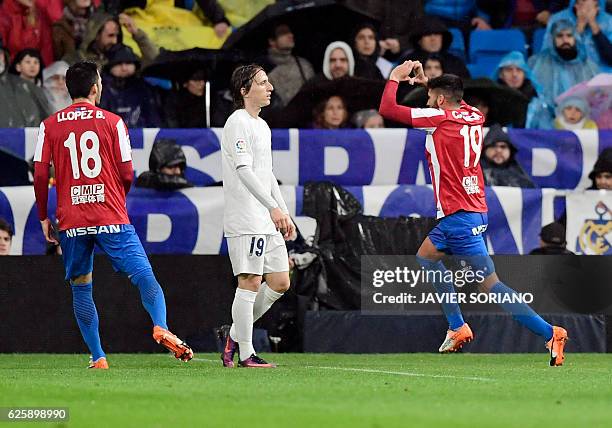 Sporting Gijon's midfielder Carlos Carmona celebrates a goal beside Real Madrid's Croatian midfielder Luka Modric during the Spanish league football...