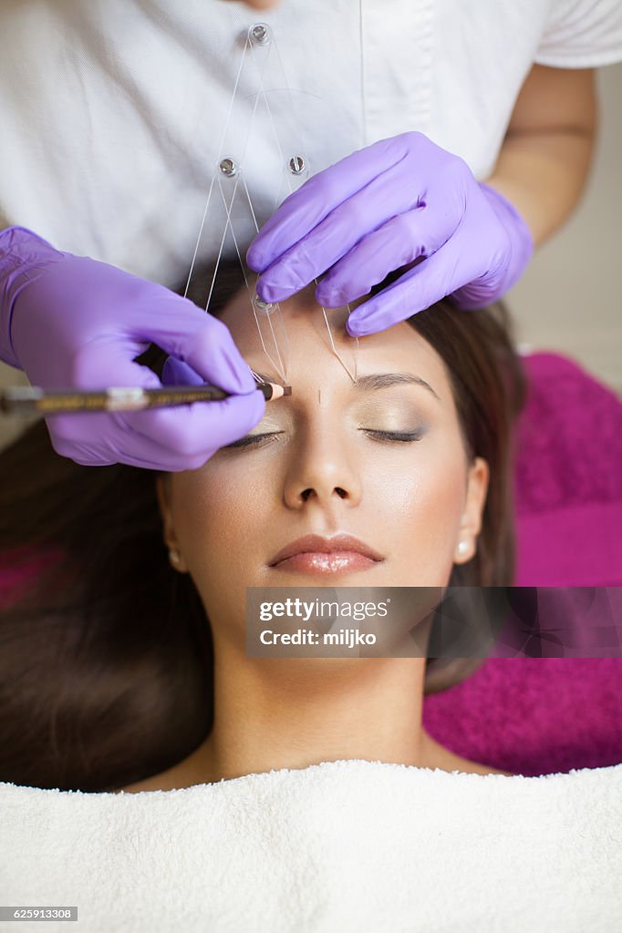 Beautiful woman in beauty slon on eyebrow makeup treatment
