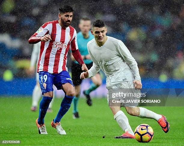 Real Madrid's Croatian midfielder Mateo Kovacic vies with Sporting Gijon's midfielder Carlos Carmona during the Spanish league football match Real...