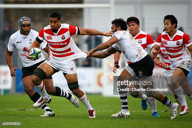 Japan's Malgene Ilaua looks to hold off the tackle from Fiji's Metuisela Talebula during the International match between Japan and Fiji at Stade de...