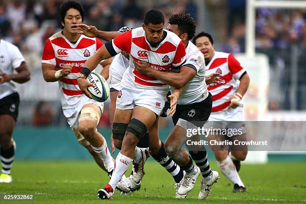 Japan's Malgene Ilaua looks to hold off the tackle from Fiji's Metuisela Talebula during the International match between Japan and Fiji at Stade de...