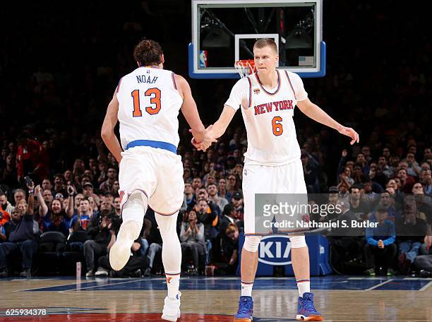 Joakim Noah and Kristaps Porzingis of the New York Knicks high five during the game against the Charlotte Hornets at Madison Square Garden in New...