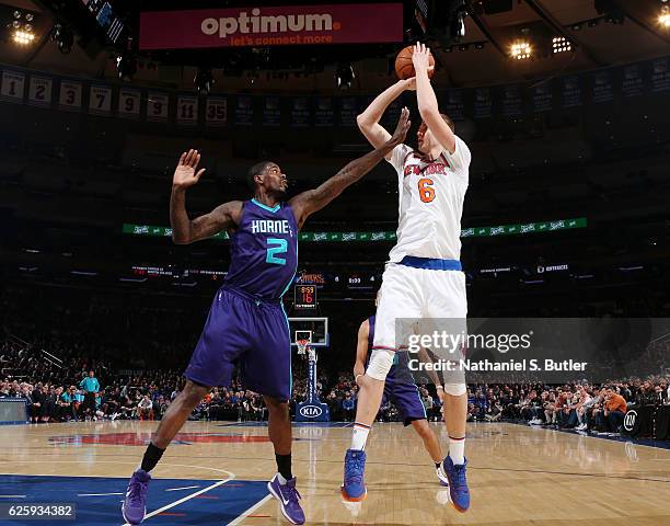 Kristaps Porzingis of the New York Knicks shoots the ball while defended by Marvin Williams of the Charlotte Hornets at Madison Square Garden in New...