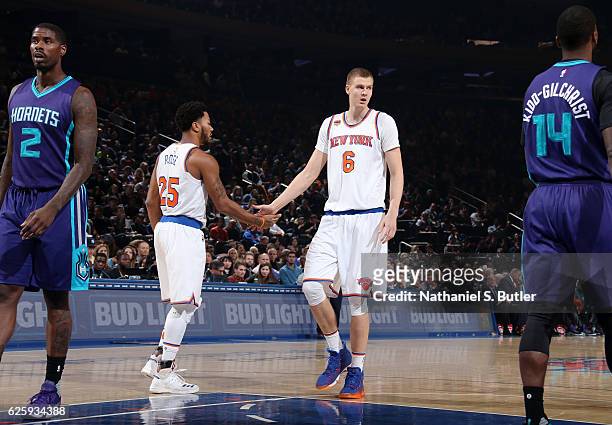 Derrick Rose and Kristaps Porzingis of the New York Knicks high five during the game against the Charlotte Hornets at Madison Square Garden in New...