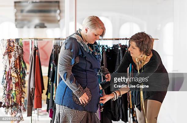fasion designer  taking customer measurement in clothing boutique - lise gagne stock pictures, royalty-free photos & images