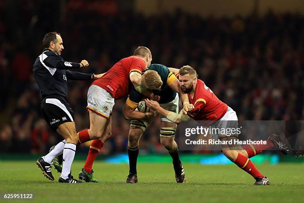 Pieter-Steph du Toit of South Africa is tackled by Gethin Jenkins and Tomas Francis of Wales during the international match between Wales and South...