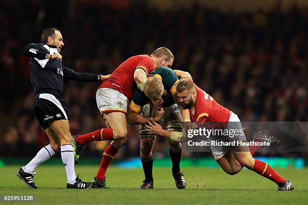 Pieter-Steph du Toit of South Africa is tackled by Gethin Jenkins and Tomas Francis of Wales during the international match between Wales and South...