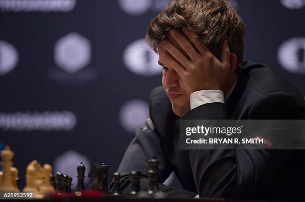 Magnus Carlsen, Norwegian chess grandmaster and current World Chess Champion, holds his head while playing against Sergey Karjakin, Russian chess...