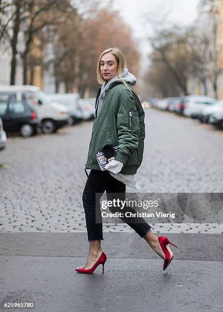 Sonia Lyson wearing red heel pumps manolo blahnik, black cropped denim jeans Zara, grey hoody weekday white blouse weekday, khaki bomber jacket...