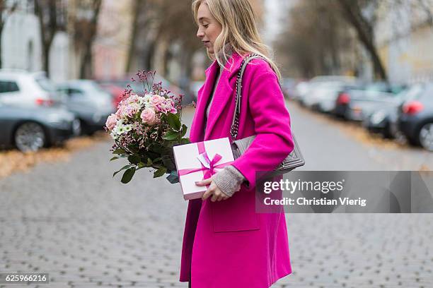 Sonia Lyson with a valentines day bunch of roses and gift wearing a pink Lala Berlin wool coat, Lala Berlin turtleneck sweater, grey Chanel bag,...