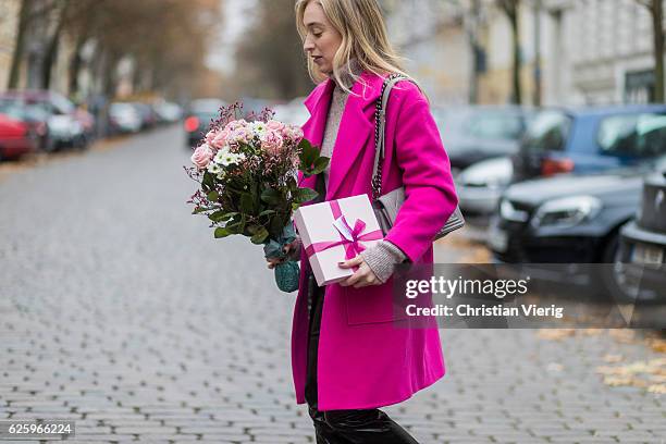 Sonia Lyson with a valentines day bunch of roses and gift wearing a pink Lala Berlin wool coat, Lala Berlin turtleneck sweater, grey Chanel bag,...