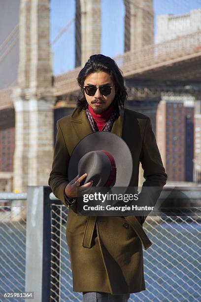 Denny Balmaceda seen wearing grey wool Krammer & Stoudt two piece suit, red ribbed cotton polo neck turtleneck top by Uniqlo, olive green wool Zara...