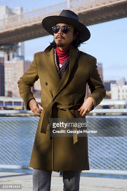 Denny Balmaceda seen wearing grey wool Krammer & Stoudt two piece suit, red ribbed cotton polo neck turtleneck top by Uniqlo, olive green wool Zara...
