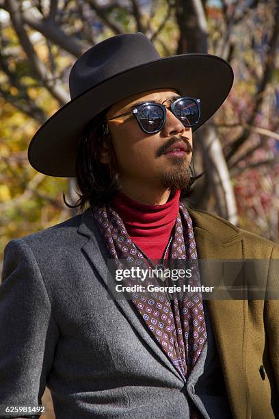 Denny Balmaceda seen wearing grey wool Krammer & Stoudt two piece suit, red ribbed cotton polo neck turtleneck top by Uniqlo, olive green wool Zara...