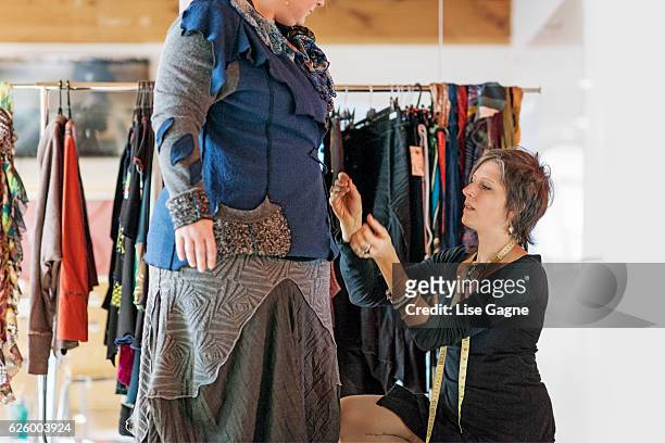 fasion designer  taking customer measurement in clothing boutique - lise gagne stock pictures, royalty-free photos & images