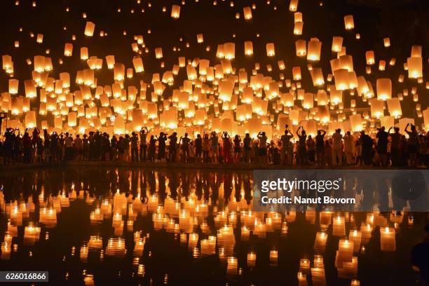 floating lanterns in thailand : reflection - yi peng stock pictures, royalty-free photos & images