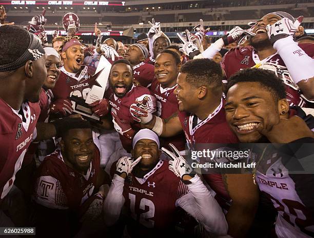 The Temple Owls celebrate with the American Athletic Conference East Division trophy after the game against the East Carolina Pirates at Lincoln...