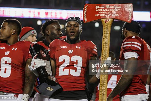 Wisconsin Badgers running back Dare Ogunbowale celebrates with the Big Ten West trophy and Paul Bunyan's Axe after an NCAA Football game between the...