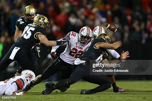 Defensive back Chase Hansen of the Utah Utes punches the ball loose from quarterback Sefo Liufau of the Colorado Buffaloes during the third quarter...