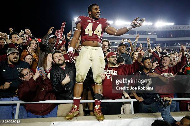 DeMarcus Walker of the Florida State Seminoles celebrates with fans after the game against the Florida Gators at Doak Campbell Stadium on November...